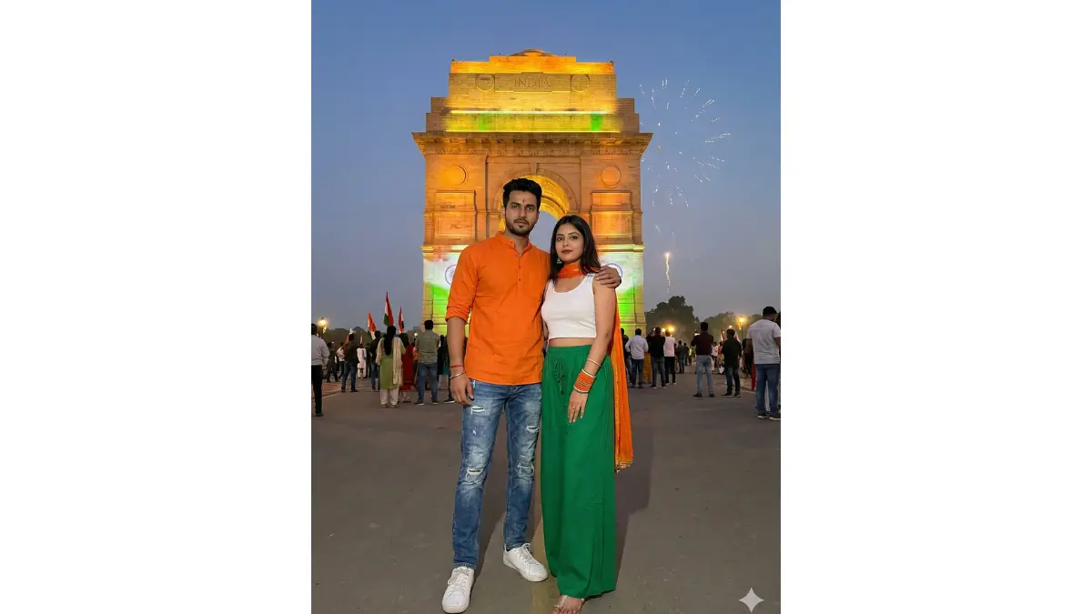 A confident modern couple posing dramatically in front of the iconic India Gate at dusk on Republic Day, illuminated by warm golden lights and projections of the Indian national flag; the man wearing contemporary fusion attire like distressed blue jeans paired with a saffron kurta shirt and white sneakers; the woman in a chic white crop top, green palazzo pants, and saffron accessories; they stand close, one arm around each other, symbolising unity and national pride